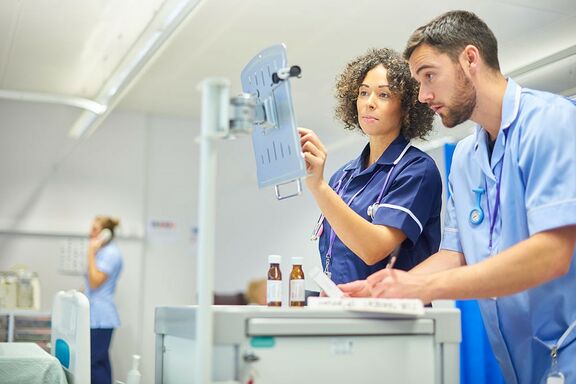 Pflegerin und Pfleger sehen in Krankenhaus an Bildschirm