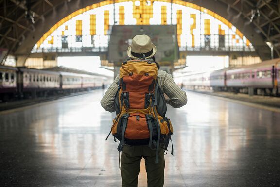 Mann mit Backpacking Rucksack der am Bahnhof steht
