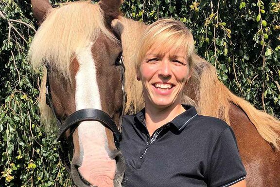 Studierende Jennifer Liffers lächelt neben ihrem Pferd Watson