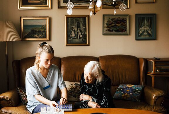 Sozialarbeiterin mit Seniorin in ihrem zuhause