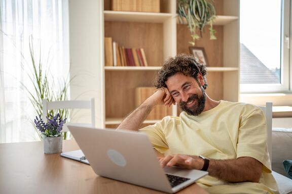 Ein Mann sitzt zuhause am Laptop