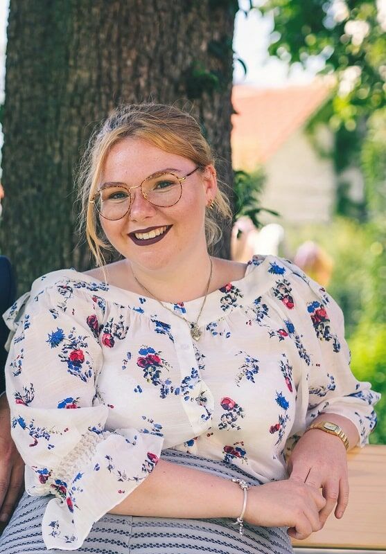 Luisa Weggerle lachend vor einem Baum sitzend