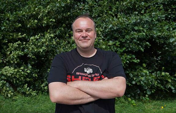 Stephan Vogt mit verschränkten Armen im T-Shirt