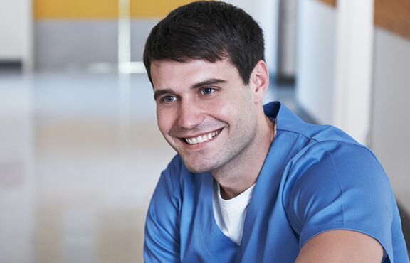 Junger Mann aus der Pflege im Gespräch mit älterer Person