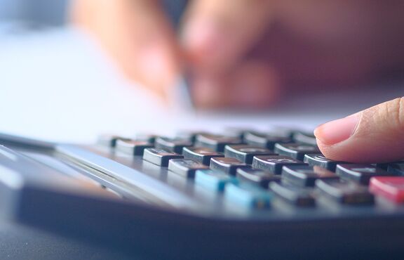 Finger auf Taschenrechner