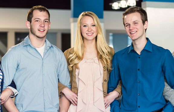 Fünf Schüler:innen stehen eingehakt nebeneinander