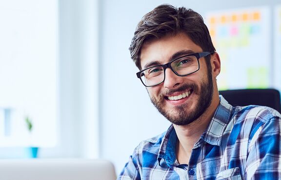 Lächelnder Mann vor Canban-Board