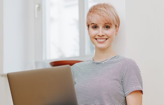 Frau mit Notebook auf Boden sitzend