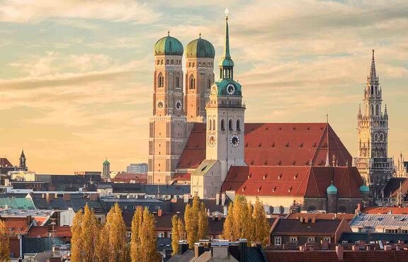 Münchens Skyline bei Sonnenuntergang mit Blick auf die berühmte St. Peter Kirche, die Frauenkirche und St. Michael, Deutschland.