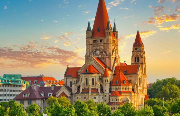 Wiener Skyline mit berühmter Franz-von-Assisi-Kirche bei wunderschönem Sonnenuntergang, Wien.