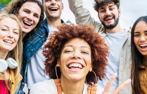 junge Menschen schießen lachend ein Selfie