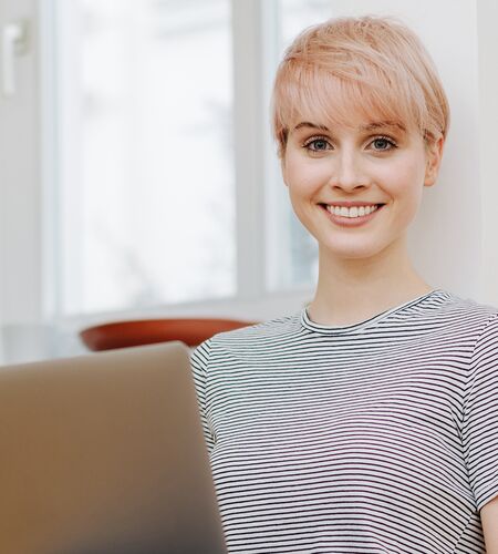 Frau mit Notebook auf Boden sitzend