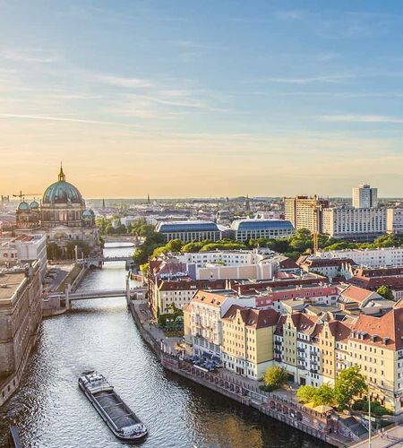 Luftaufnahme der Berliner Skyline mit berühmtem Fernsehturm und Spree bei wunderschönem Abendlicht bei Sonnenuntergang, Deutschland.