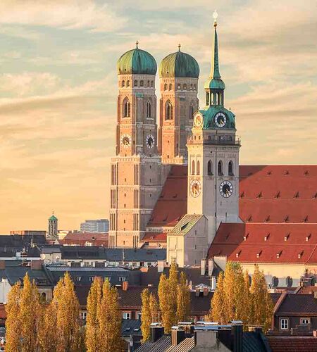 Münchens Skyline bei Sonnenuntergang mit Blick auf die berühmte St. Peter Kirche, die Frauenkirche und St. Michael, Deutschland.