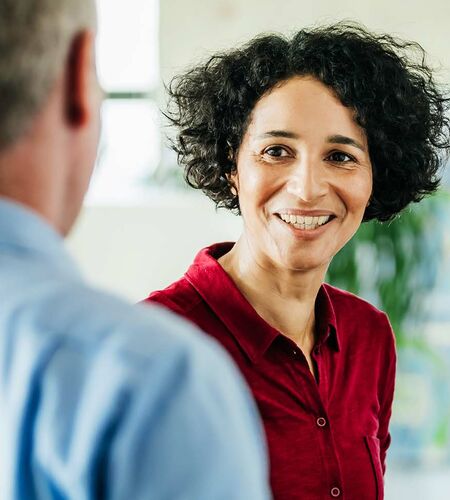 Studierende und Mitarbeitende stehen gut gelaunt im Kreis und tauschen sich aus zu Fragen rund ums Studium