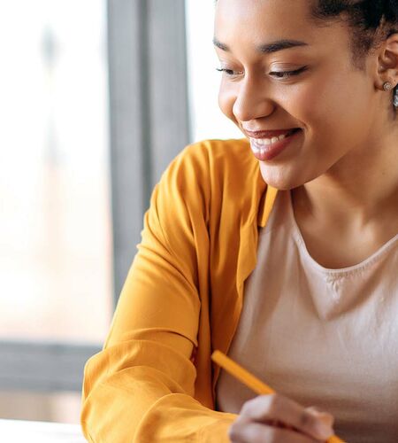 Studierende arbeitet und lernt am Laptop mit Unterlagen 