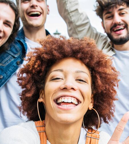 junge Menschen schießen lachend ein Selfie