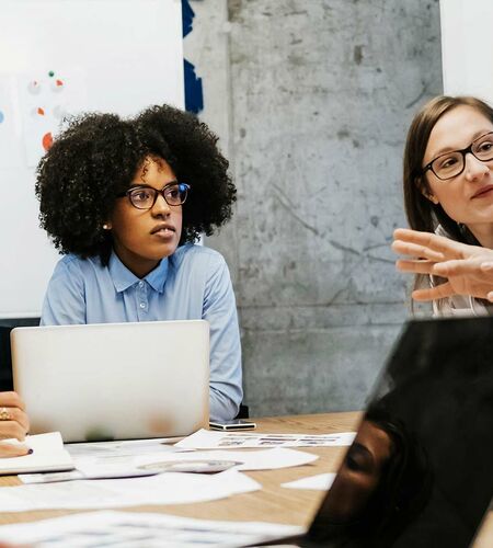 Fünf junge Forschende sitzen an einem Tisch und diskutieren