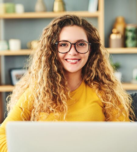 Fernstudentin sitzt zuhause vor ihrem Laptop 