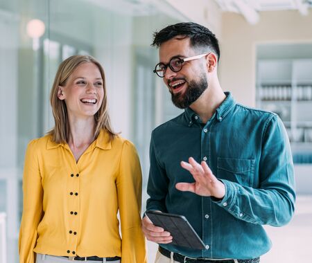 Kolleg*innen unterhalten sich gut gelaunt im Flur eines Büros