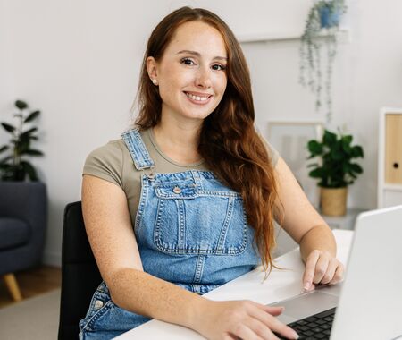 Junge Frau am Schreibtisch freundlich lächelnd