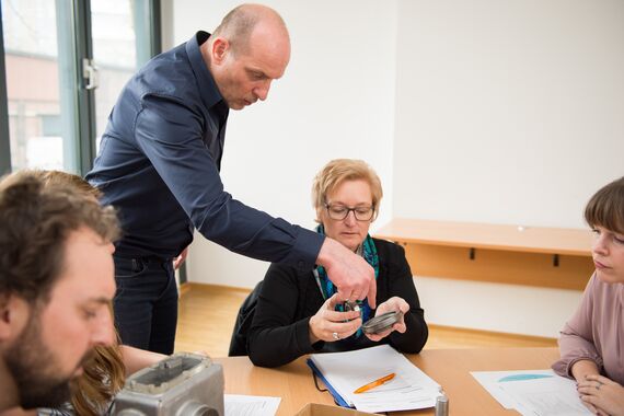 Fernstudium-Lehrender erklärt der Lerngruppe ein Bauteil