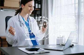 Junge Frau in Arztkleidung an Tisch vor Notebook mit eingeblendeten digitalen Symbolen im Bild