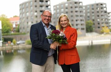 Prof. Dr. Lars Binckebanck überreicht Blumenstrauß an Prof. Dr. Irina Kummert am Osterbekkanal.