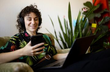 Aufstiegsstipendium März 2025 Eine Person mit Laptop und Handy.
