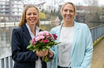 Prof. Dr. Birgit Schröder (links) und HFH-Präsidentin Prof. Dr. Cathleen Gaede-Illig (rechts) bei Übergabe eines Blumenstraußes.