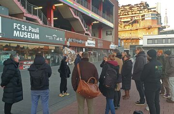 Gruppe von Menschen steht vor dem Millerntor-Stadion in Hamburg.