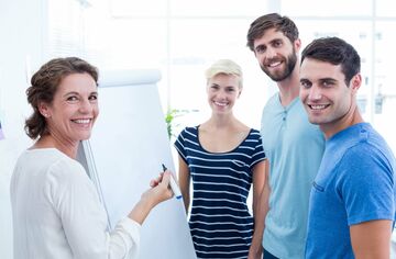 Vier Personen stehen an einem Flipchart