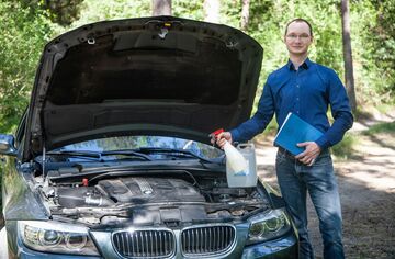 Stefan Nahs, Absolvent des Bachelors Wirtschaftsingenieurwesen der HFH, vor Auto mit geöffneter Motorhaube.