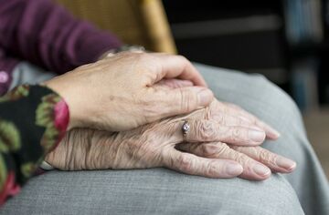 Zwei Hände älterer Menschen übereinander liegend