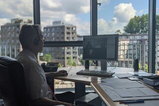 Mann sitzt am Fenster am PC und nimmt an Online-Konferenz teil 