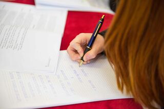 Studentin beim Lernen mit einem Studienbrief