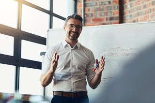 Businessman stehend vor Flipchart bei einer Präsentation