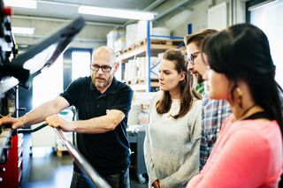 Studierende an Maschine
