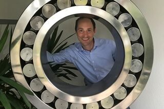 HFH-Absolvent Dr. Philipp Schmid vor großem Kugellager