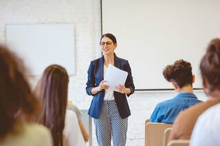 Dozentin doziert vor Gruppe Studierender
