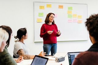 Dozentin referiert vor Whiteboard