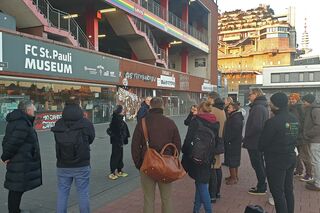 Gruppe von Menschen steht vor dem Millerntor-Stadion in Hamburg.