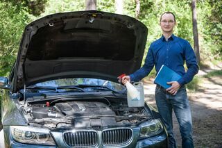 Stefan Nahs, Absolvent des Bachelors Wirtschaftsingenieurwesen der HFH, vor Auto mit geöffneter Motorhaube.