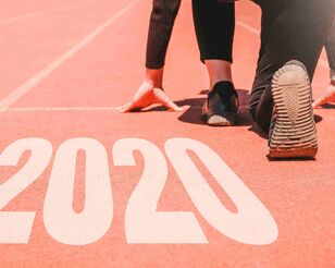 Schuhe eines Leichtathleten beim Start und Schriftzug 2020