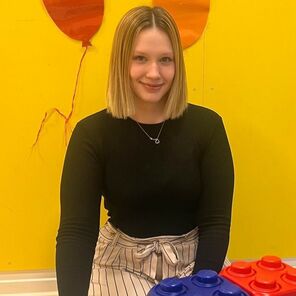 Foto Madeleine Becker vor gelber Wand