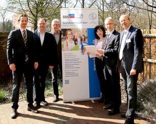 Vertreter/-innen der HFH und der BSS 14 vor einem Roll-Up