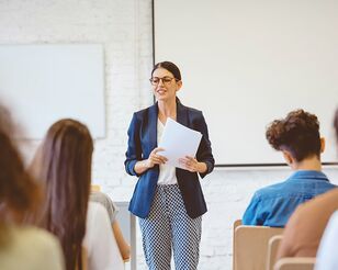 Dozentin doziert vor Gruppe Studierender