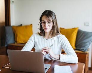 Studentin sitzt vor ihrem Laptop