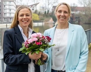 Prof. Dr. Birgit Schröder (links) und HFH-Präsidentin Prof. Dr. Cathleen Gaede-Illig (rechts) bei Übergabe eines Blumenstraußes.
