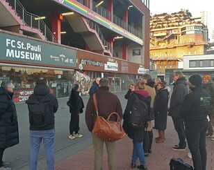 Gruppe von Menschen steht vor dem Millerntor-Stadion in Hamburg.